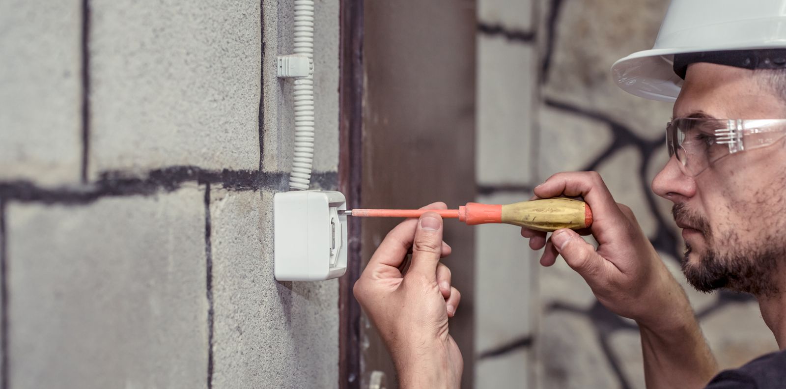 Electrician autorizat ANRE montând o priză într-un apartament din București
